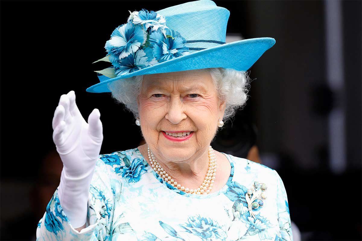 Королева Елизавета использует искусственную руку для приветствия публики.
