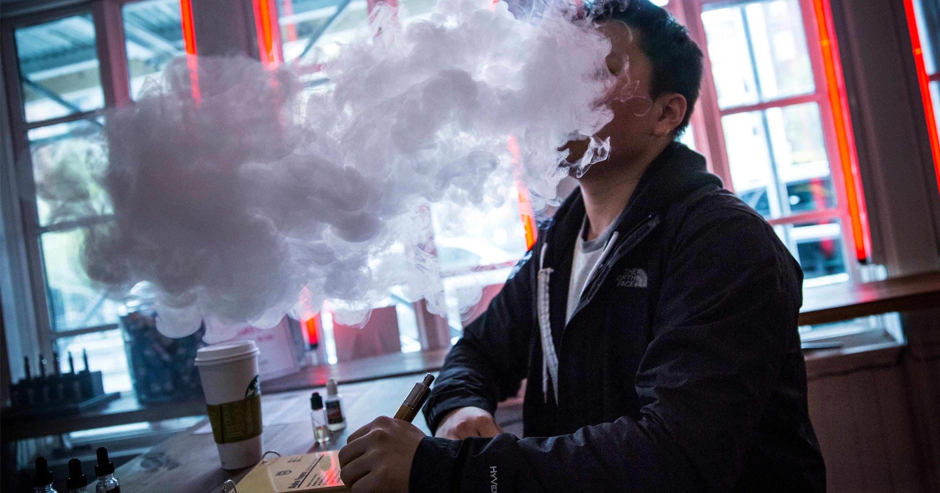 Парить или курить. Дым от вейпа. Мужчина в дыму. Человек с электронной сигаретой. Курение вейпа.